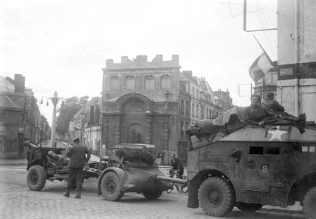 Photographie noir et blanc montrant des chars et des soldats dans des rues.