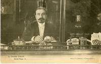 Photographie noir et blanc du docteur François Calot assis derrière son bureau. 