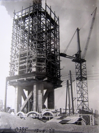 Photographie noir et blanc d'un échaffaudage et d'une grue.