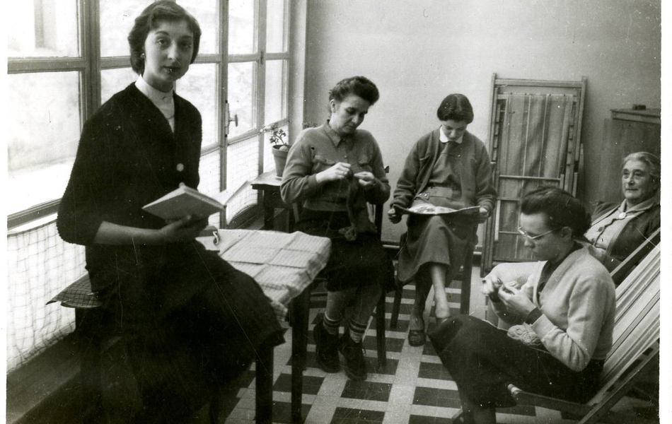 Photographie noir et blanc de cinq femmes assises, en train de lire ou de tricoter.