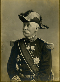 Photographie noir et blanc montrant un homme vêtu d'un costume militaire et portant des insignes.