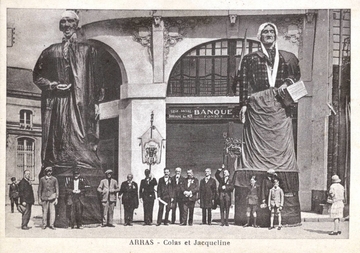 Carte postale noir et blanc montrant un groupe de personnes posant devant un couple de géants.