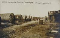 Photographie noir et blanc montrant des baraquements au milieu de gravas.