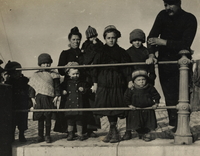 Photographie noir et blanc montrant une famille composée de sept enfants, alignés devant une balustrade.