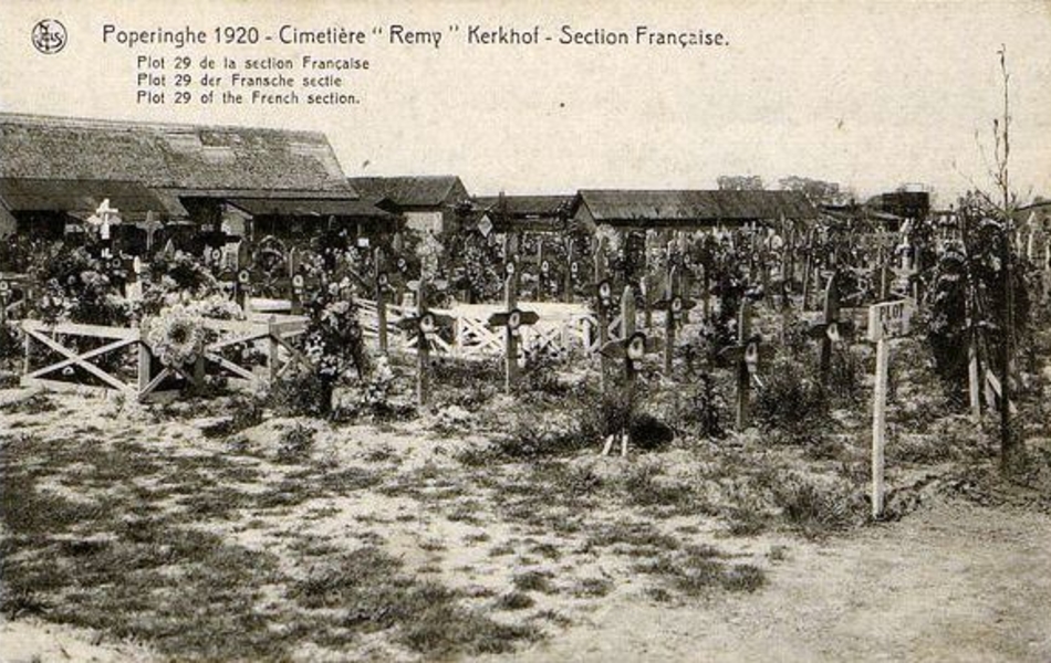 Carte postale noir et blanc montrant un cimetière de croix de bois qui portent des cocardes tricolores.