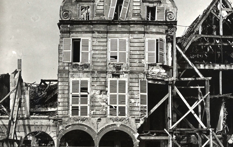 Photographie noir et blanc montrant les ruines d'une maison éventrée.