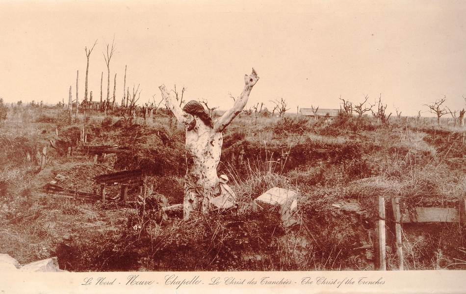 Photographie sépia montrant un Christ en croix coupé en deux, pklanté dans le sol, dans un paysage de ruines.