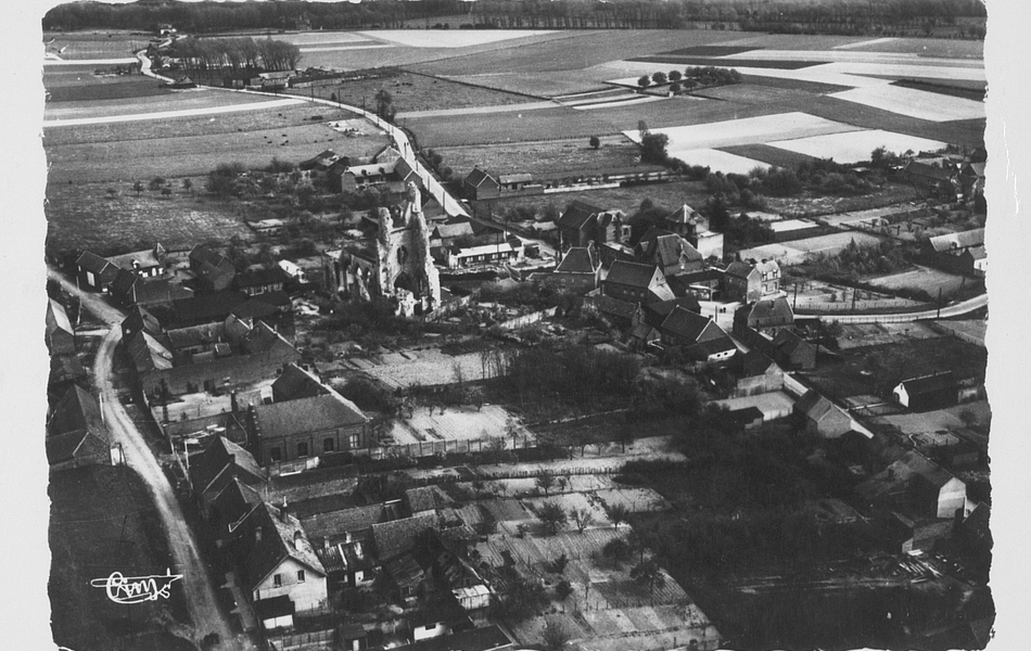 Vue aérienne d'un village construit autour d'une église en ruines.