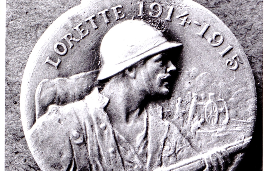 Photographie noir et blanc d'une médaille ronde à l'effigie d'un poilu brandissant son fusil.