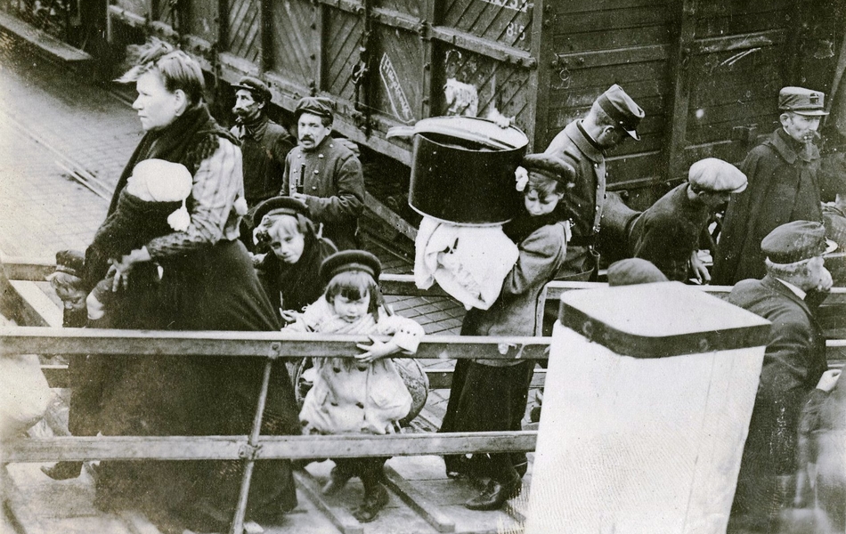 Photographie noir et blanc montrant des femmes chargées de bagages embarquant sur un paquebot.