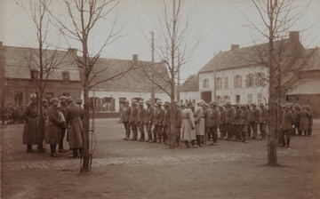 Photographie sepia montrant une place sur laquelle se trouve un groupe de soldats rangés par rangs.