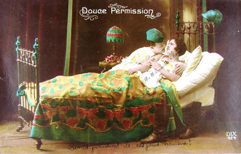 Carte postale couleur montrant un homme et une femme allongés dans un lit.