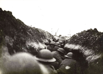 Photographie noir et blanc montrant un groupe de soldats dans une tranchée, prêts à s'élancer.
