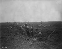 Photographie noir et blanc montrant des soldats sur un champ de bataille.