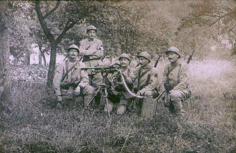 Photographie noir et blanc montrant un groupe de soldats positionné autour d'une mitraillette.
