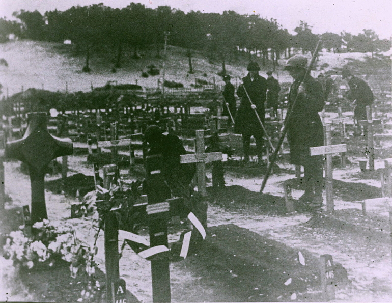 Photographie noir et blanc montrant des femmes entretenant des tombes.
