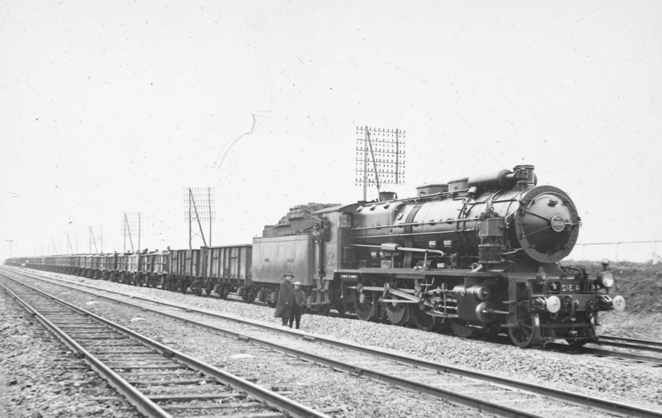 Photographie noir et blanc montrant une locomotive sur une voie ferrée.