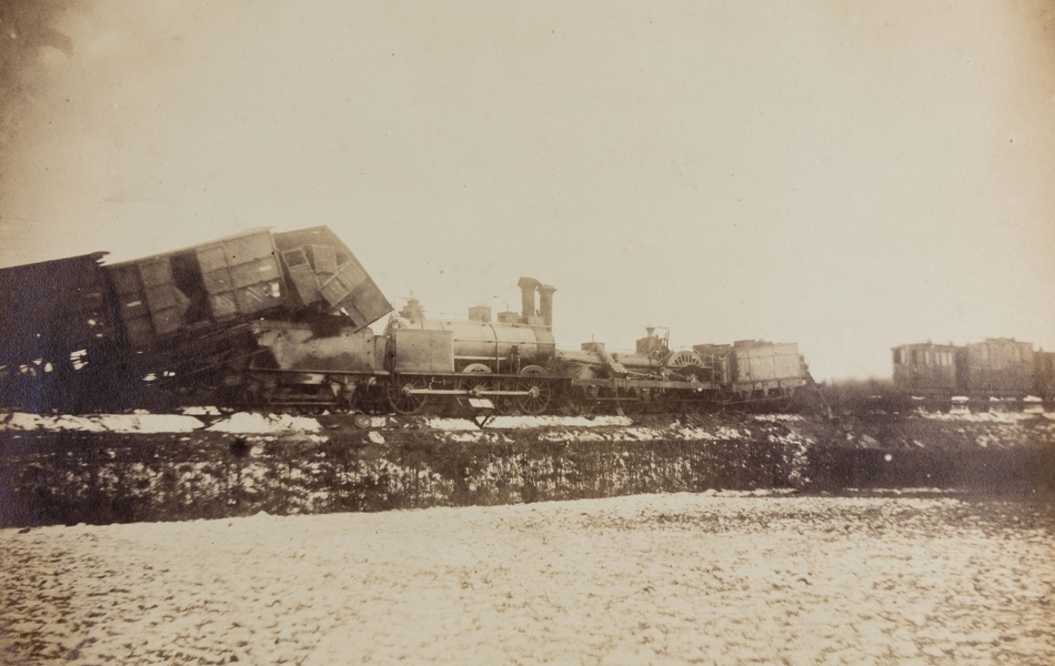 Photographie noir et blanc montrant un train déraillé. 