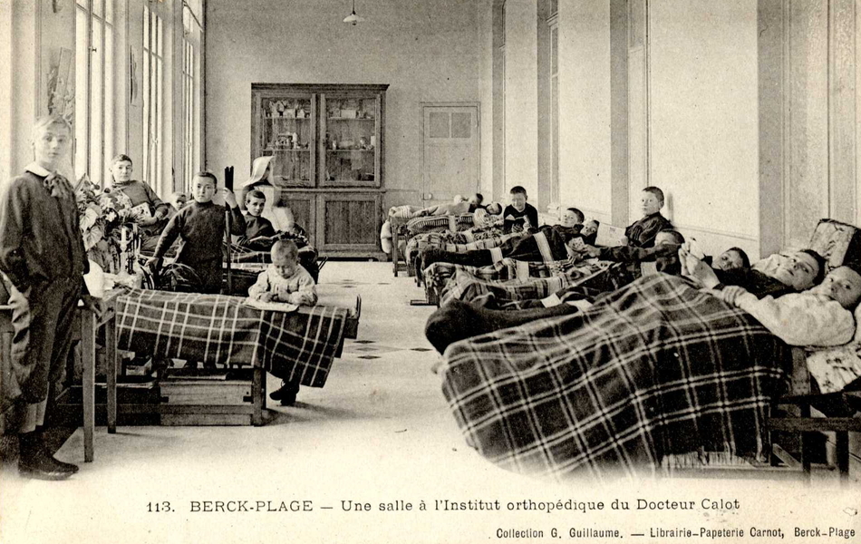 Carte postale noir et blanc montrant des enfants dans un dortoir.