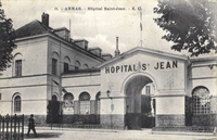 Carte postale noir et blanc montrant la façade d'un bâtiment sur lequel est écrit "hôpital Saint Jean".