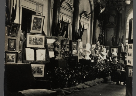 Photographie noir et blanc montrant une exposition de tableaux et de bustes.