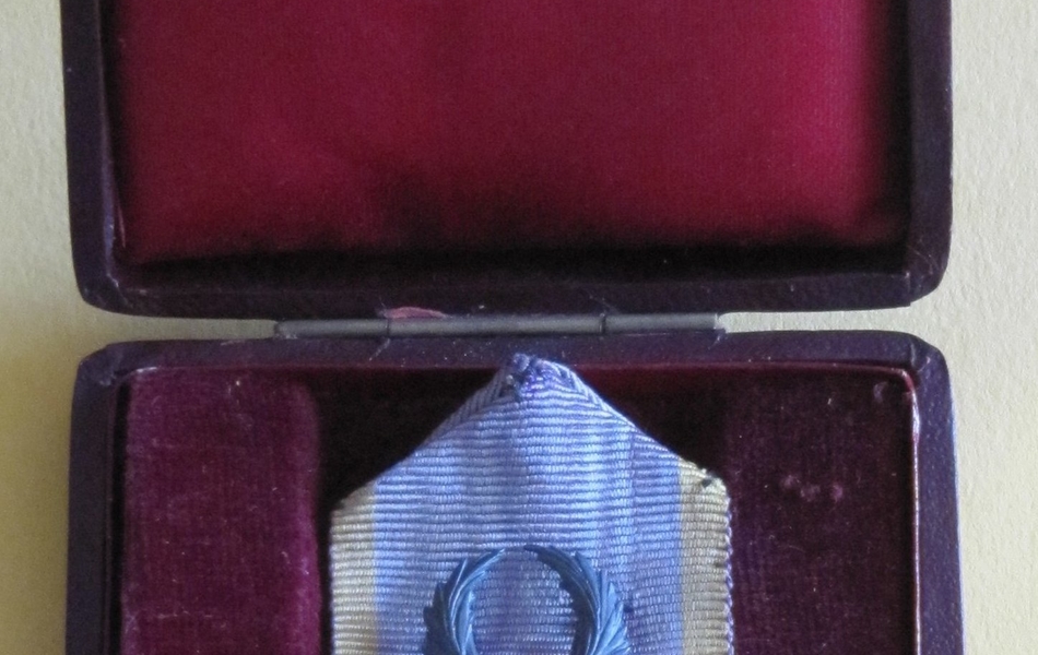 Médaille sur laquelle est gravée l'image d'une femme assise entourée de deux enfants.