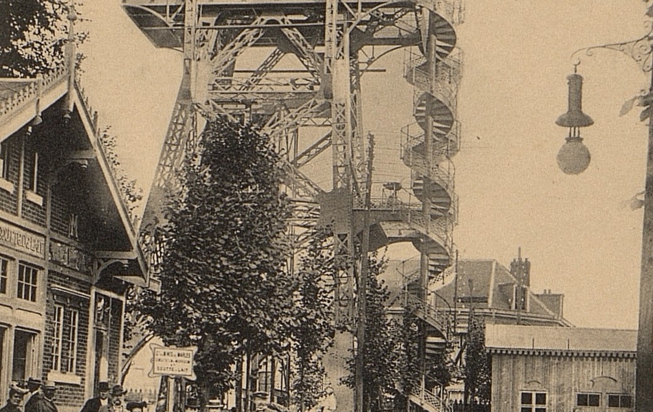 Carte postale noir et blanc montrant une grande structure métallique et un petit pavillon devant lequel sont regroupées des personnes.