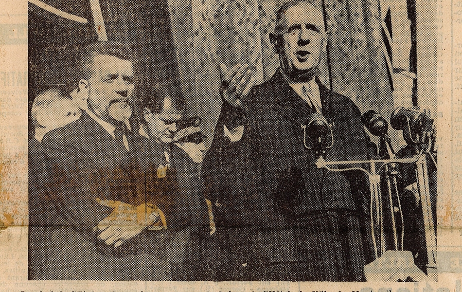 Coupure de presse montrant une photographie où l'on voir Charles de Gaulle debout au balcon de l’Hôtel de Ville, devant des micros, accompagné par le ministre des Transports. En-dessous, la légende suivante : "Le chef de l'État s'adresse à la population du balcon de l'hôtel de ville de Montreuil".