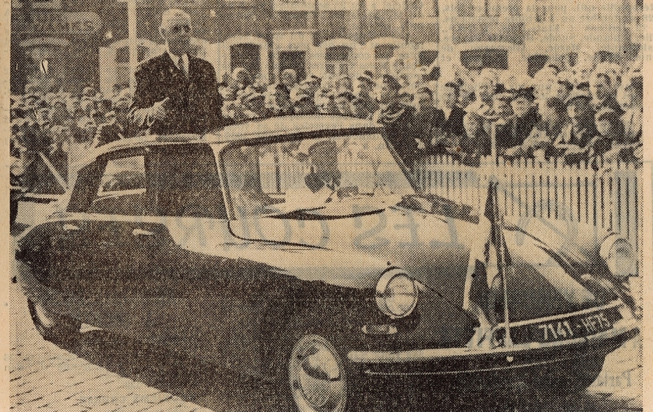 Coupure de presse illustrée d'une photographie sur laquelle on voit le général de Gaulle debout dans une voiture parée d’un drapeau, saluant la foule qui l’acclame depuis les trottoirs, derrière des barrières mises en place pour l’occasion. En-dessous, la légende suivante : "Debout dans D.S. découverte, le général salue la population boulonnaise".