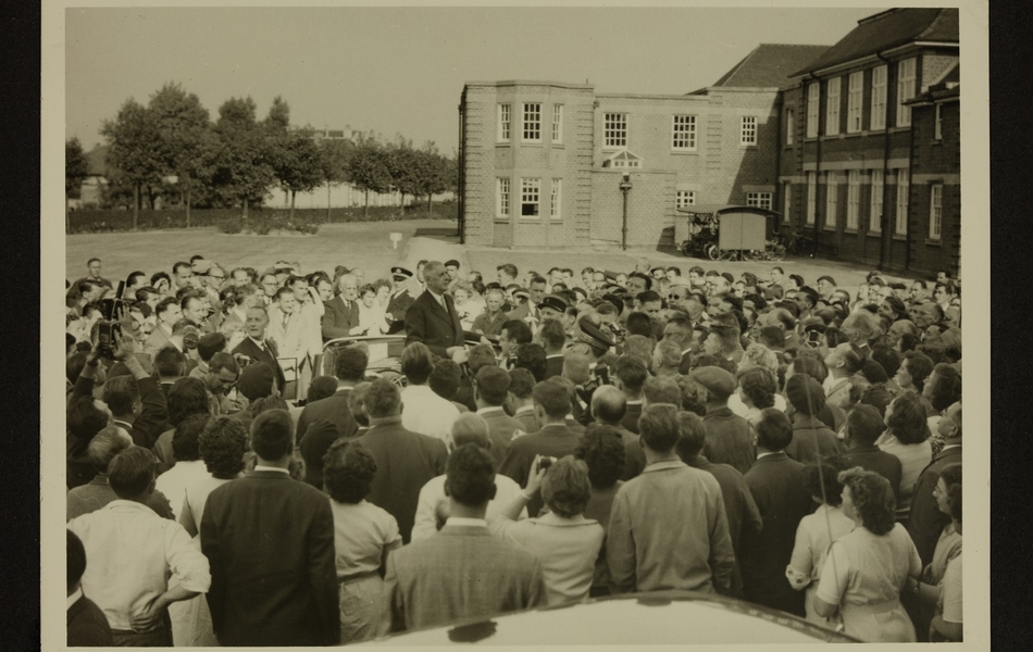 Le Général De Gaulle, Président de la République française, debout dans sa voiture décapotable, est entouré d'une foule d'employés de l'Usine des "Filés de Calais", après la visite des locaux le 24 septembre 1959.